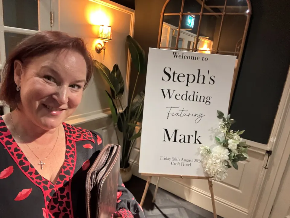 Sarah beside personalised wedding ceremony signage