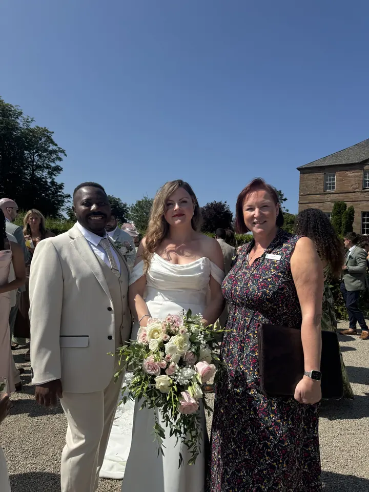 Sarah with a newly married couple after their ceremony